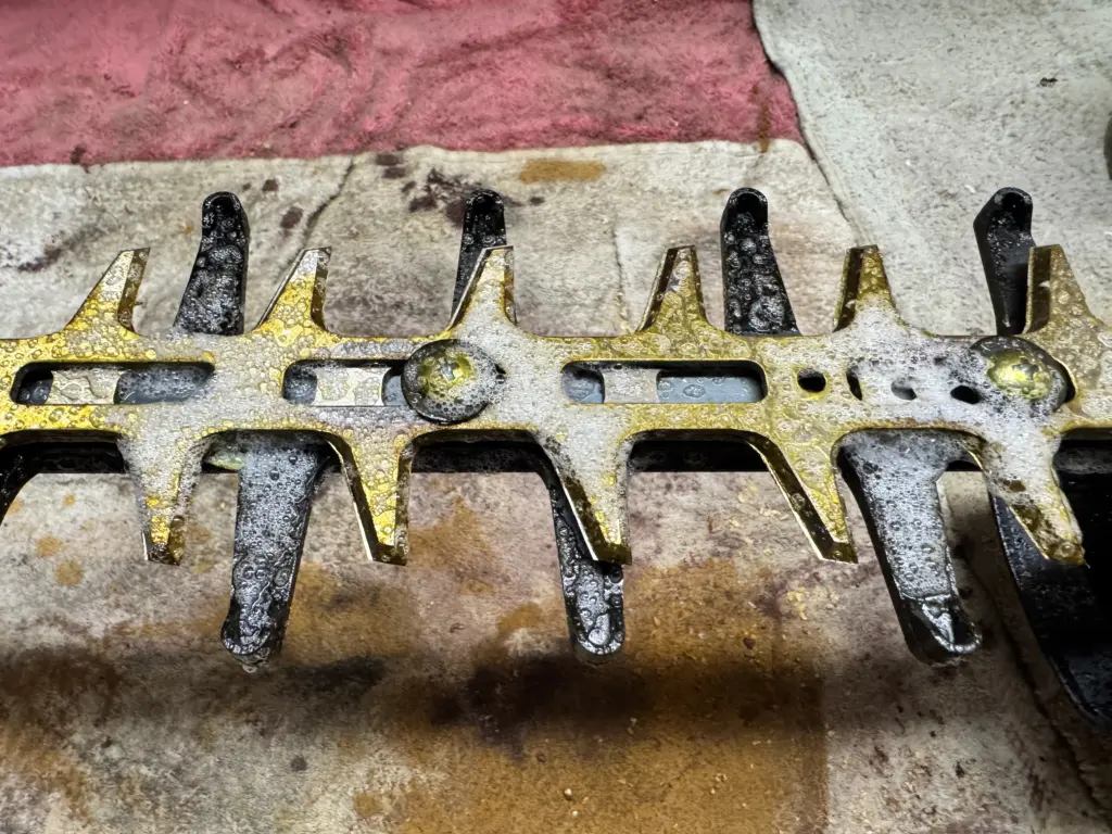 Nahaufnahme: Der Ballistol Harzlöser schäumt auf den verklebten Messern der Makita Akku-Heckenschere.