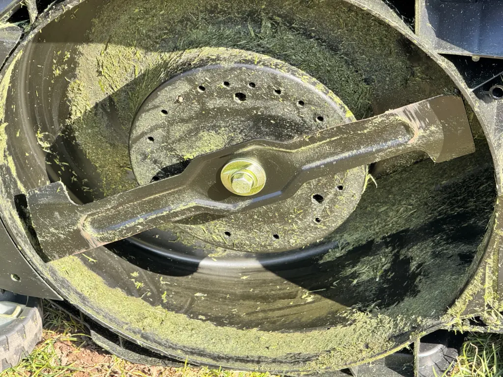 Das Mähdeck meines Makita DLM432 Akku-Rasenmähers vor der Reinigung mit viel anhaftendem Gras - das Mähdeck reinigen ist zwingend mal wieder notwendig.