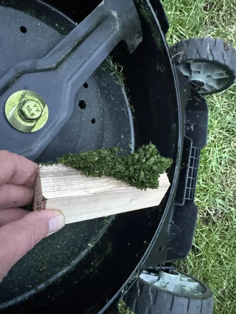 Mähdeck reinigen leicht gemacht: Grasreste lassen sich durch das PTFE-Spray einfach mit einem Holzklotz abstreifen.