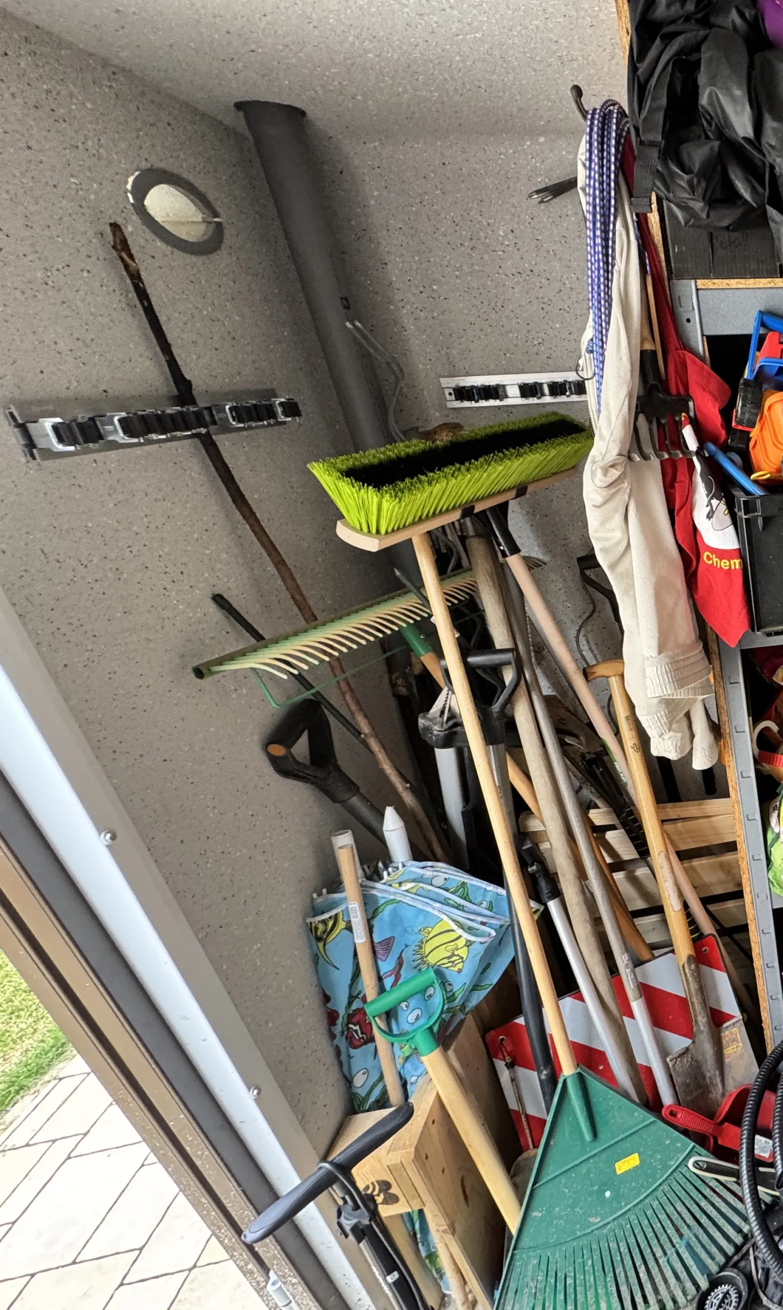 Unaufgeräumte Ecke im Schuppen mit herumliegenden Gartengeräten vor dem Bau der DIY Gartengeräte Aufbewahrung.