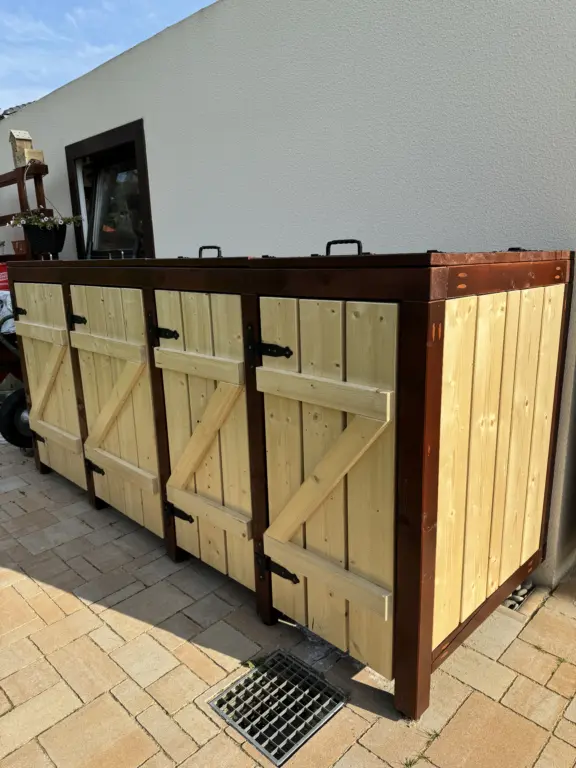 Selbstgebaute Mülltonnenbox aus Holz mit vier Stellplätzen