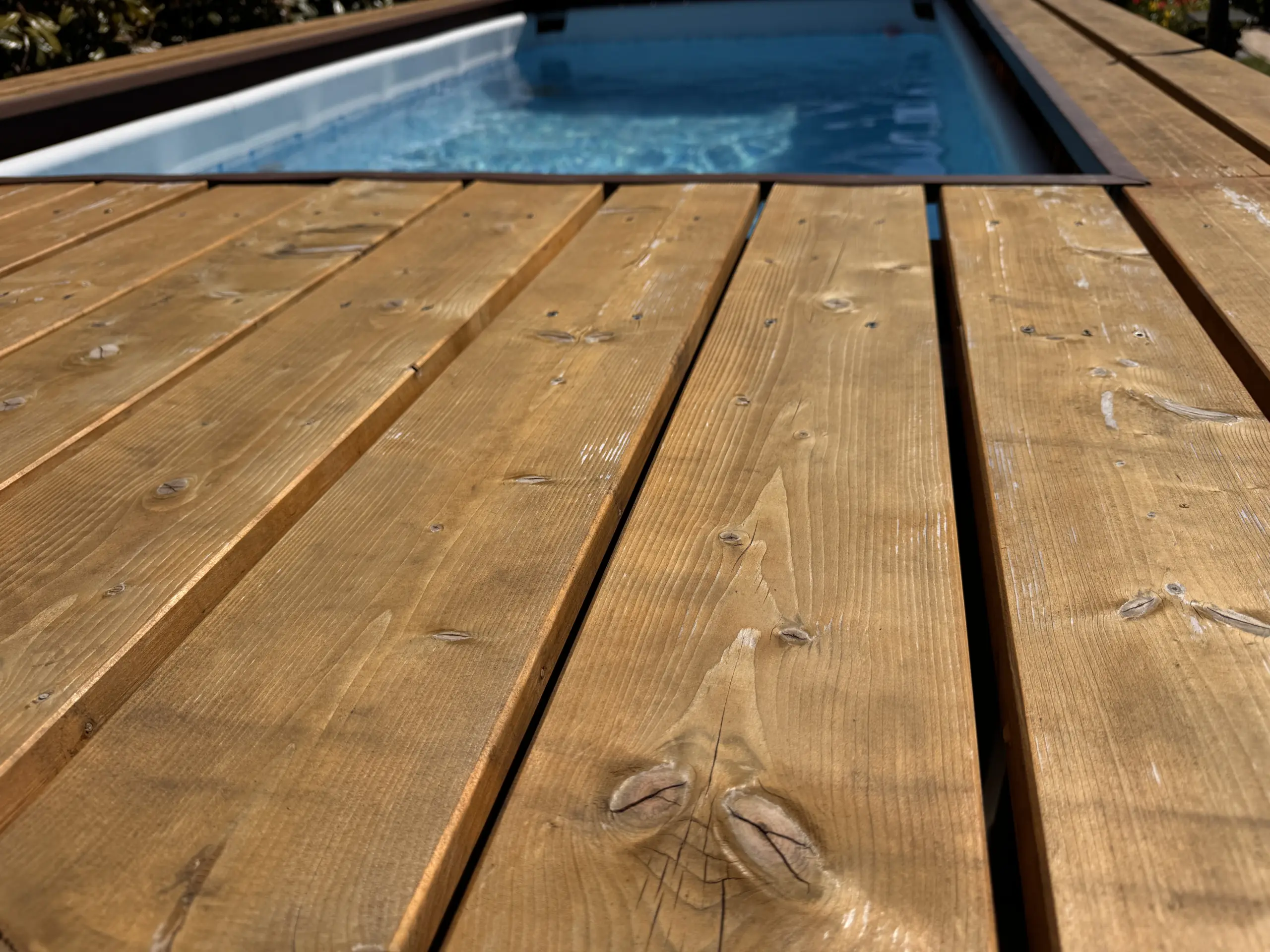 Winterschäden am Holz-Podest des Aufstellpools: Abgeplatzte Lasur muss neu gestrichen werden
