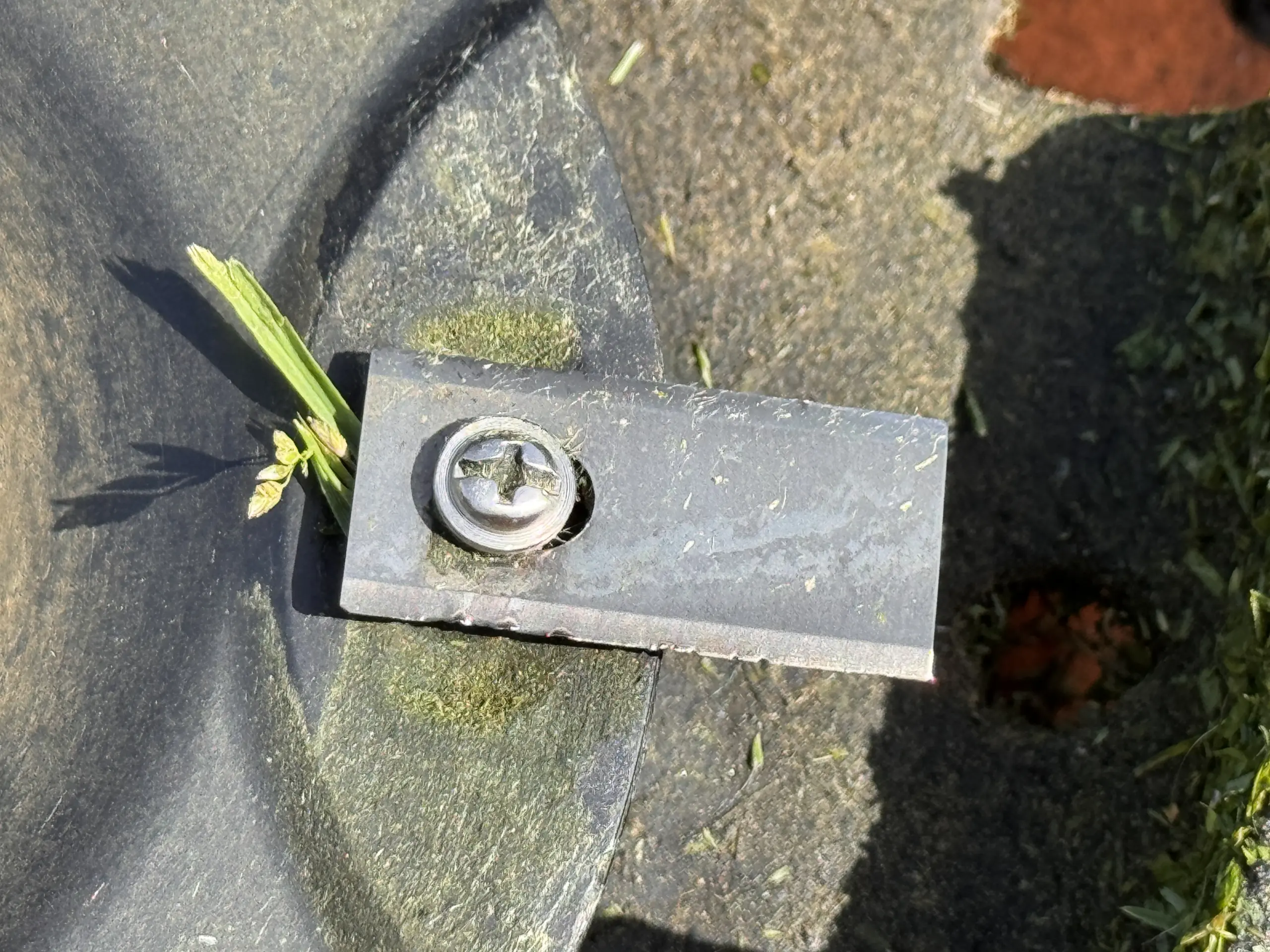 Stumpfes und beschädigtes Worx Mähroboter Messer mit grasverstopfter Schraube direkt vor dem Messerwechsel.