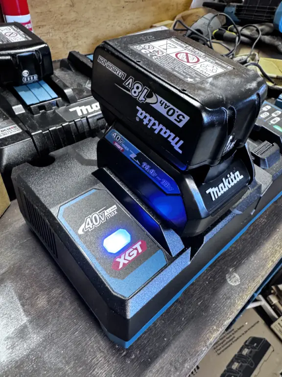 Makita 18V LXT Akku mit ADP10 Adapter auf einem XGT Ladegerät
