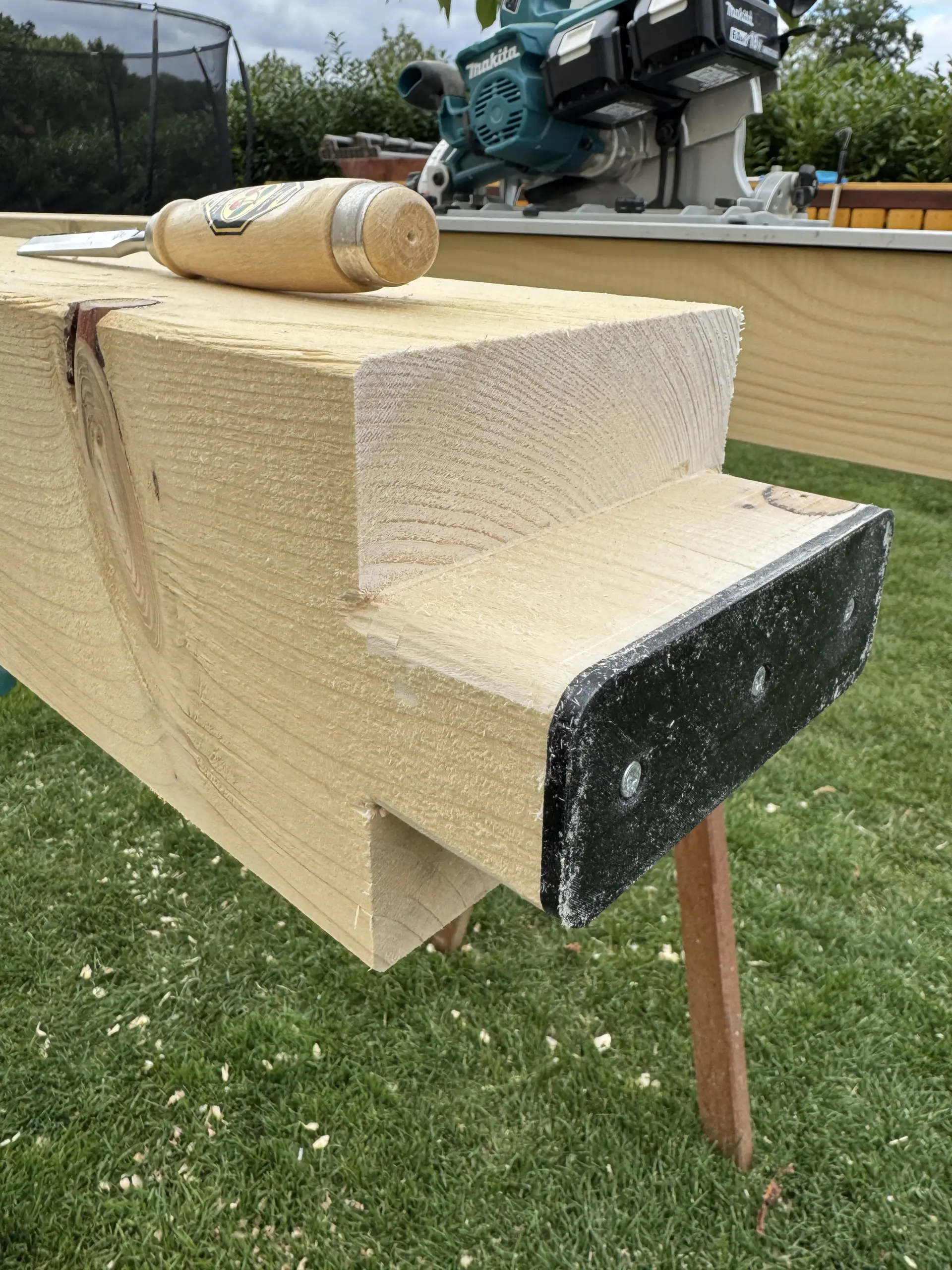 Gesägter Holzpfosten mit Stechbeitel als Beispiel für präzise Holzarbeiten beim Carportbau