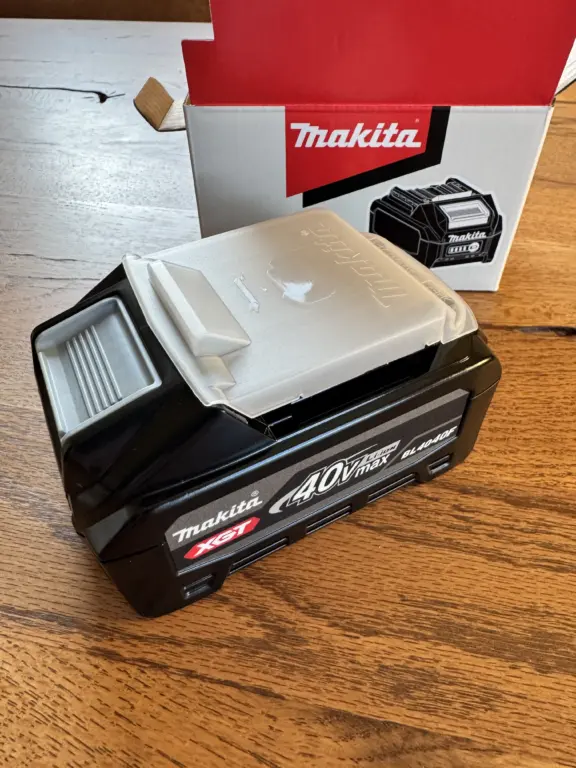 Makita BL4040F XGT 40V Akku auf Holztisch vor der Originalverpackung