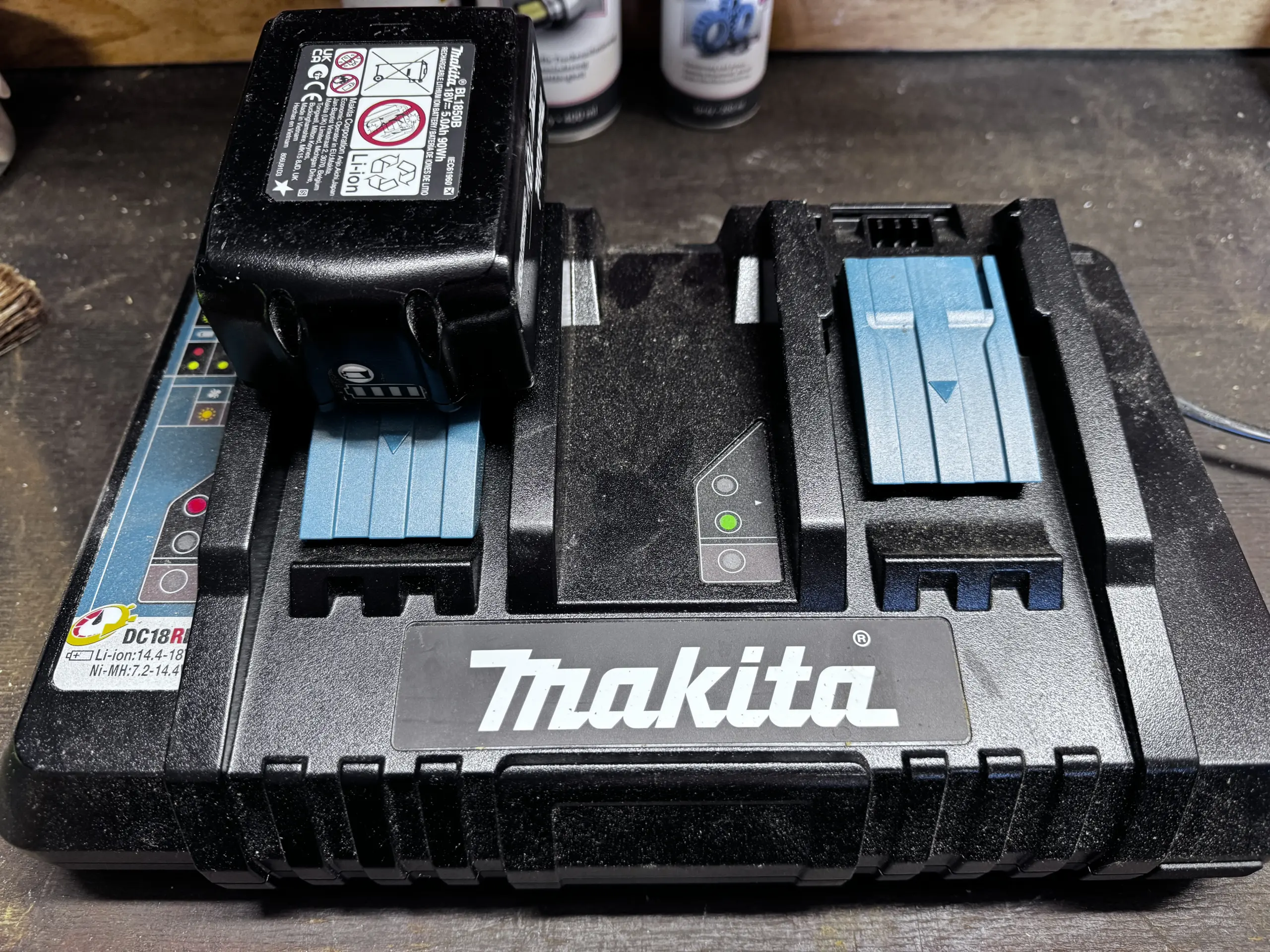 Makita DC18RD Doppelladegerät mit eingesetztem 18V LXT Akku auf der Werkbank