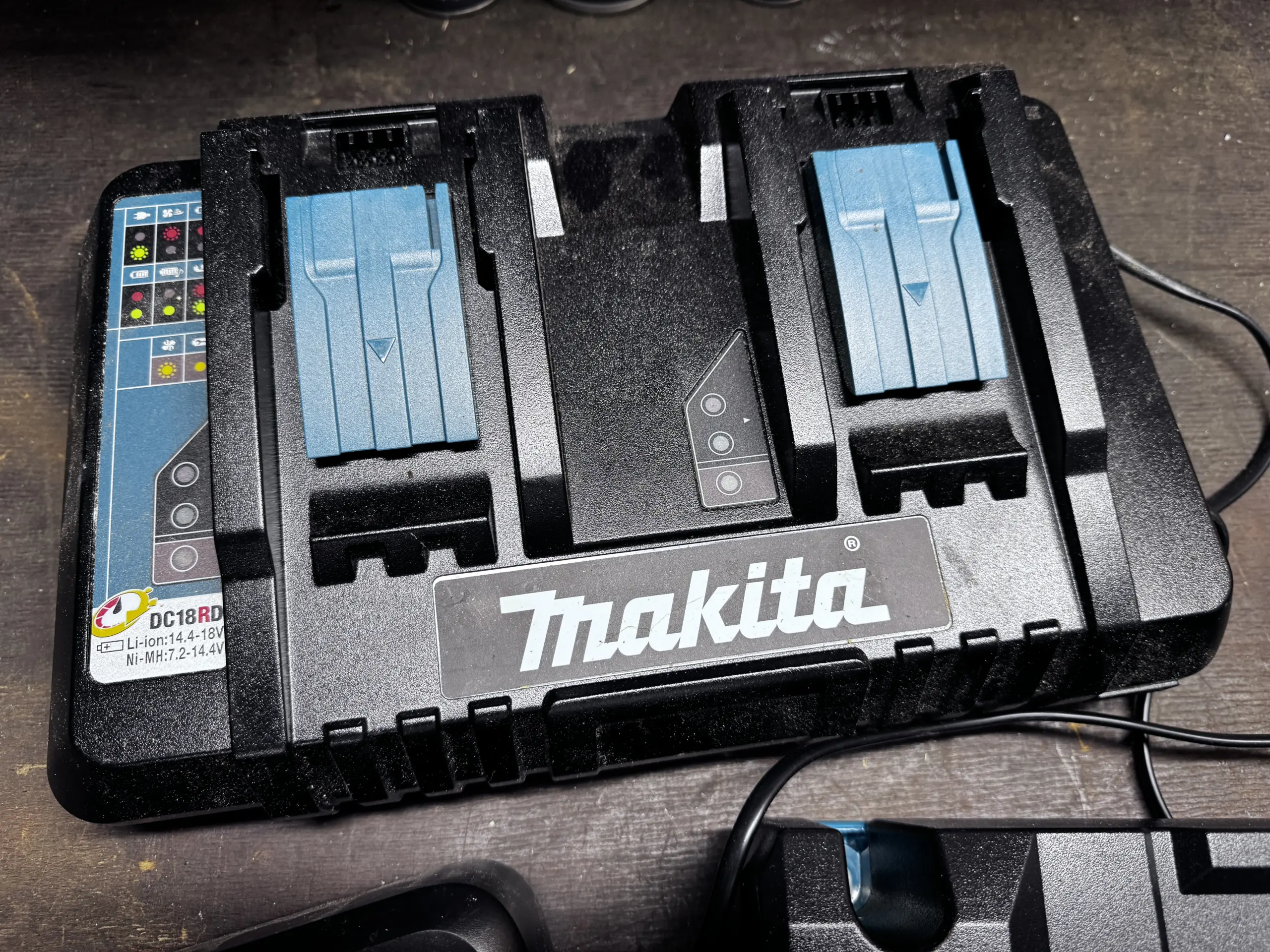 Makita DC18RD Doppelladegerät auf der Werkbank mit zwei Ladeschächten für 18V LXT Akkus