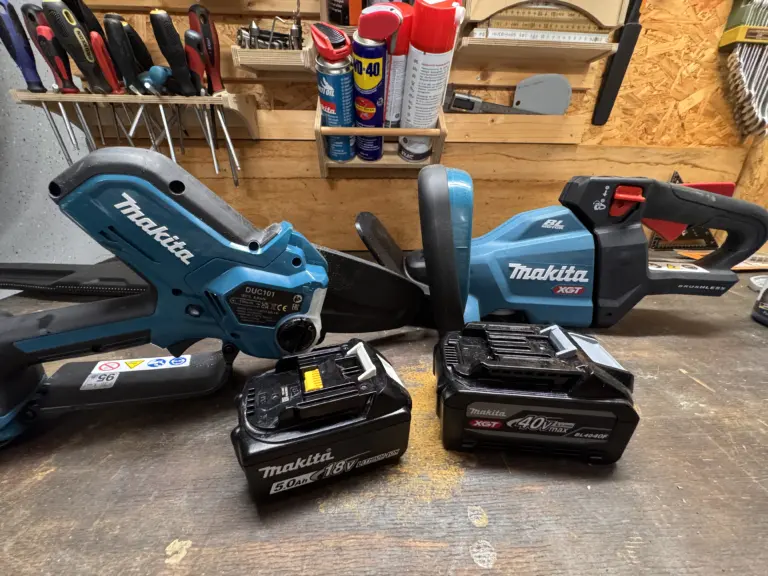 Makita DUC101 Astsäge neben einer Makita XGT Heckenschere und LXT-XGT Akkus auf der Werkbank