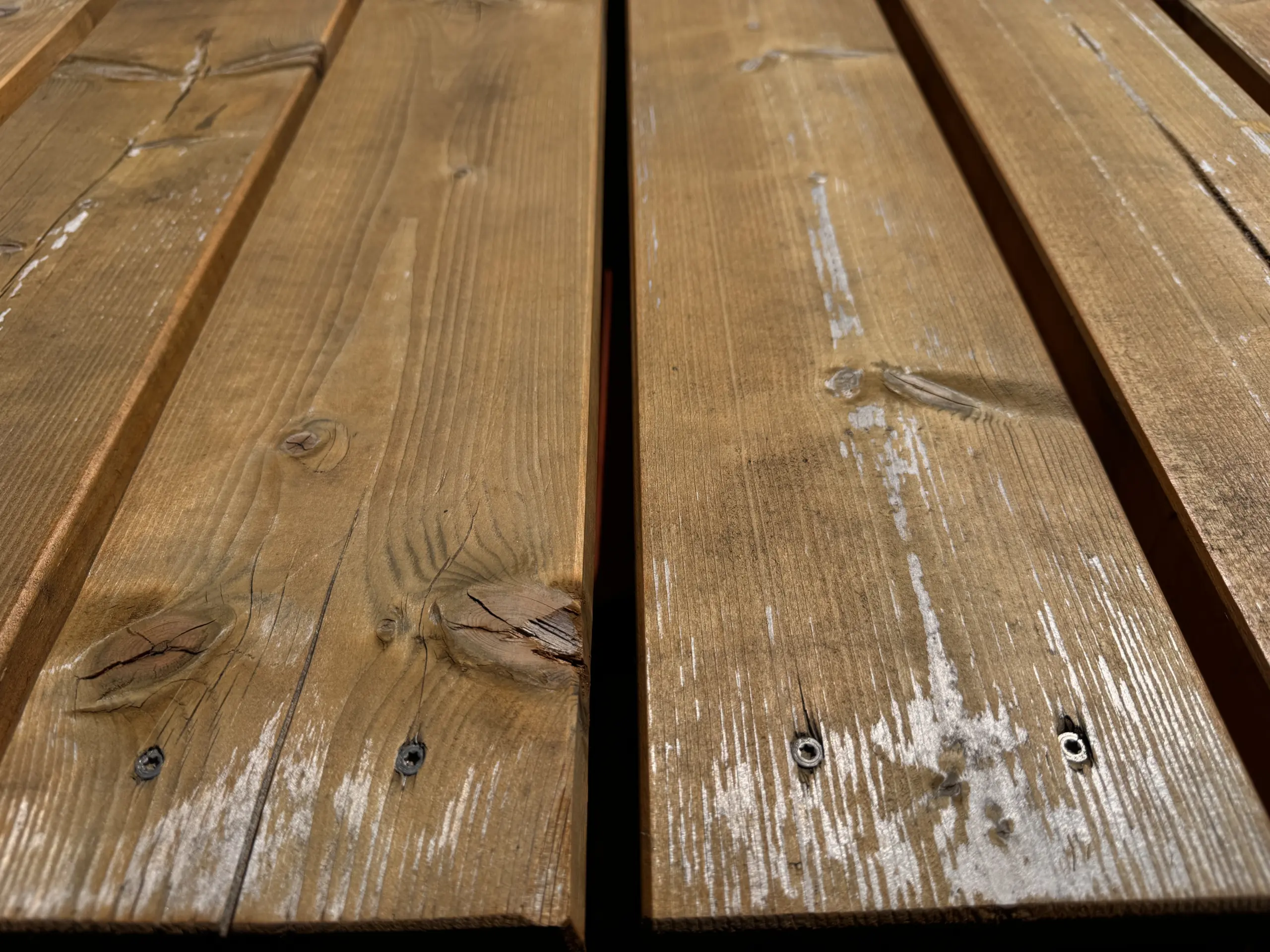 Holzdeck einer Poolumrandung mit abgenutzter Oberfläche als Beispiel für Schleifarbeiten im Garten