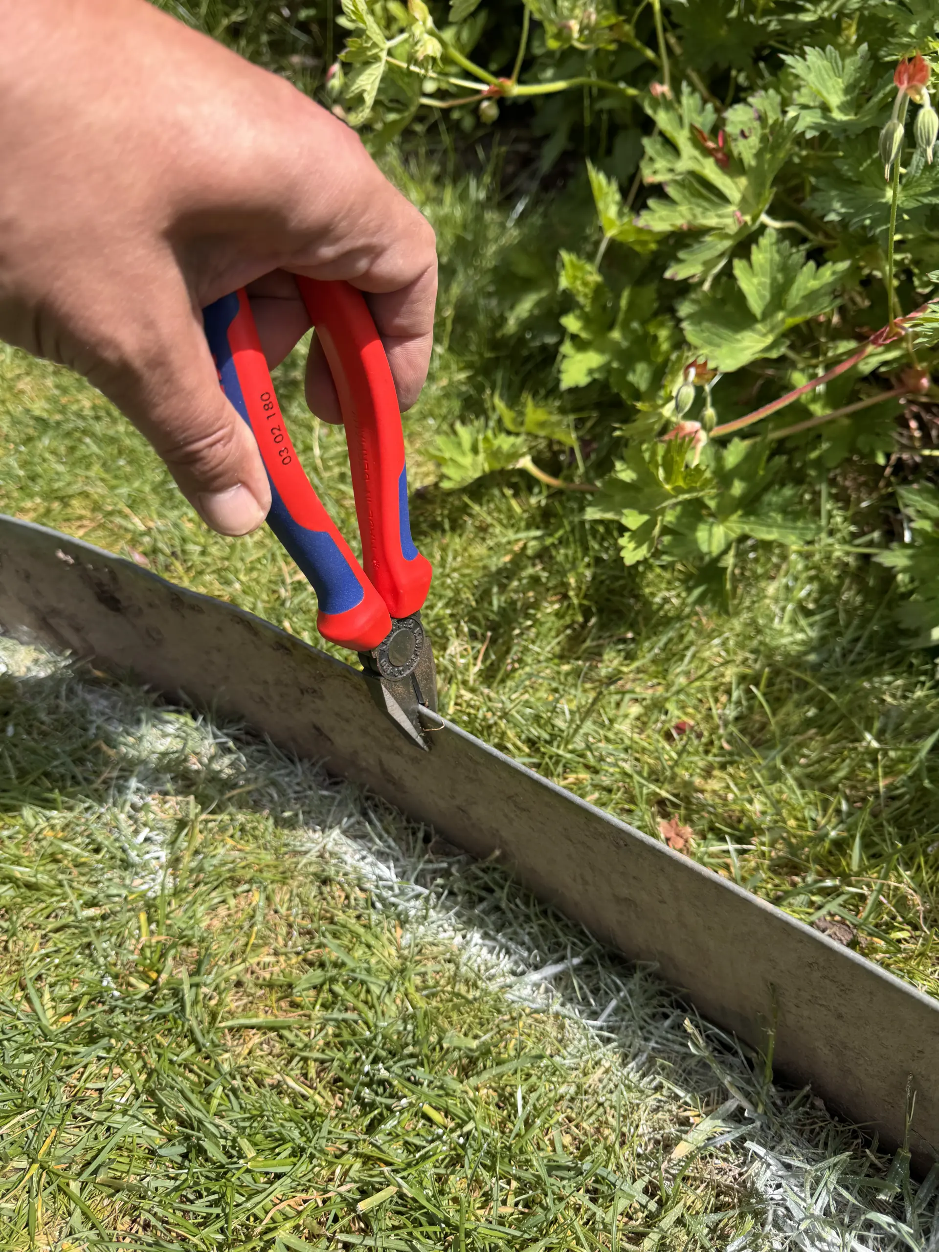 Knipex Kombizange an einer Rasenkante im Garten