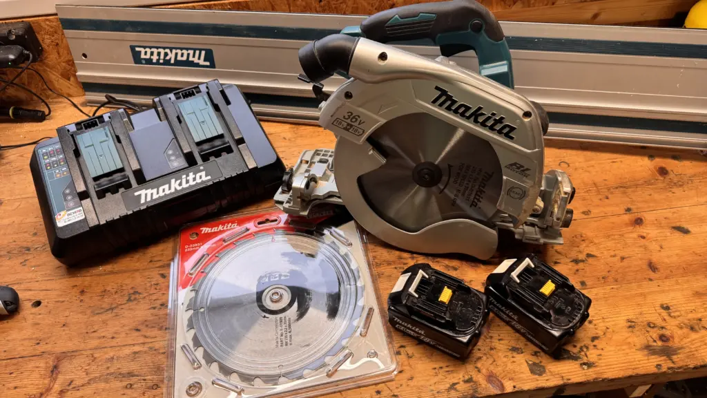 Makita DHS900 mit Führungsschiene, Ersatzsägeblatt, zwei Akkus und DC18RD