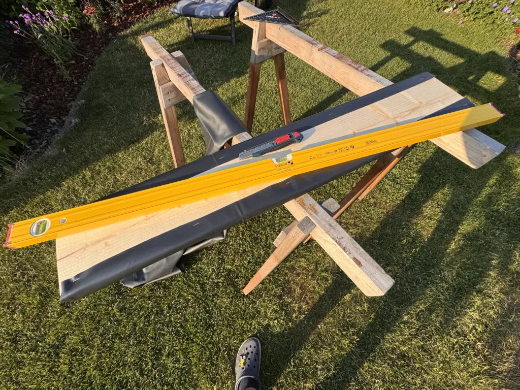Lange STABILA Wasserwaage auf Holzbalken bei einem eigenen Bauprojekt im Garten