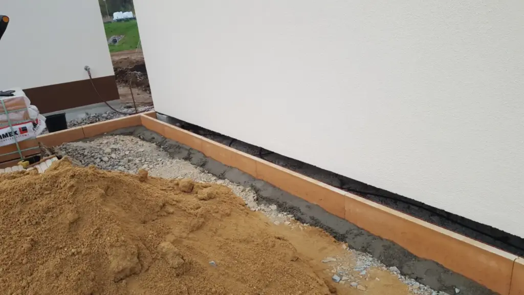 Gesetzte Bordsteine entlang der Hauswand bei den Pflasterarbeiten