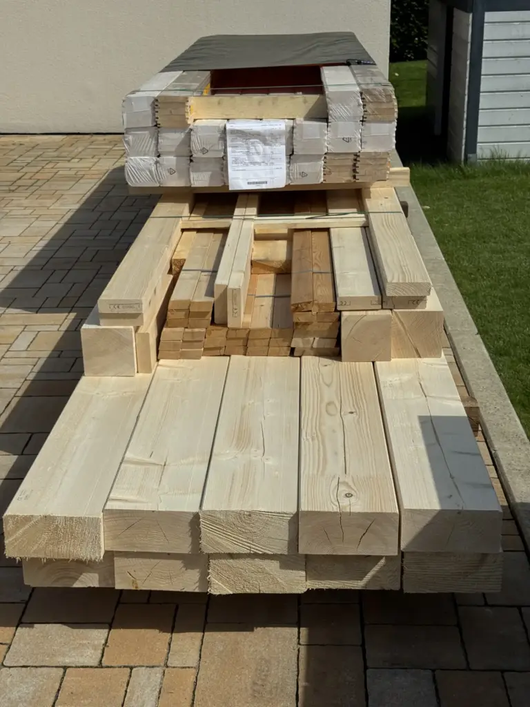 Unbehandeltes Carport-Holz vor dem Schleifen – große Holzmenge als Ausgangslage