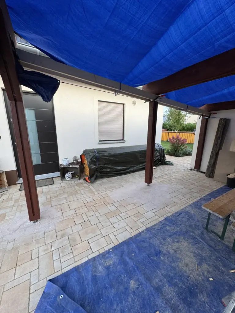 Dunkel gestrichene Carport-Pfosten und Pfetten in Osmo 703 Mahagoni während der Bauphase