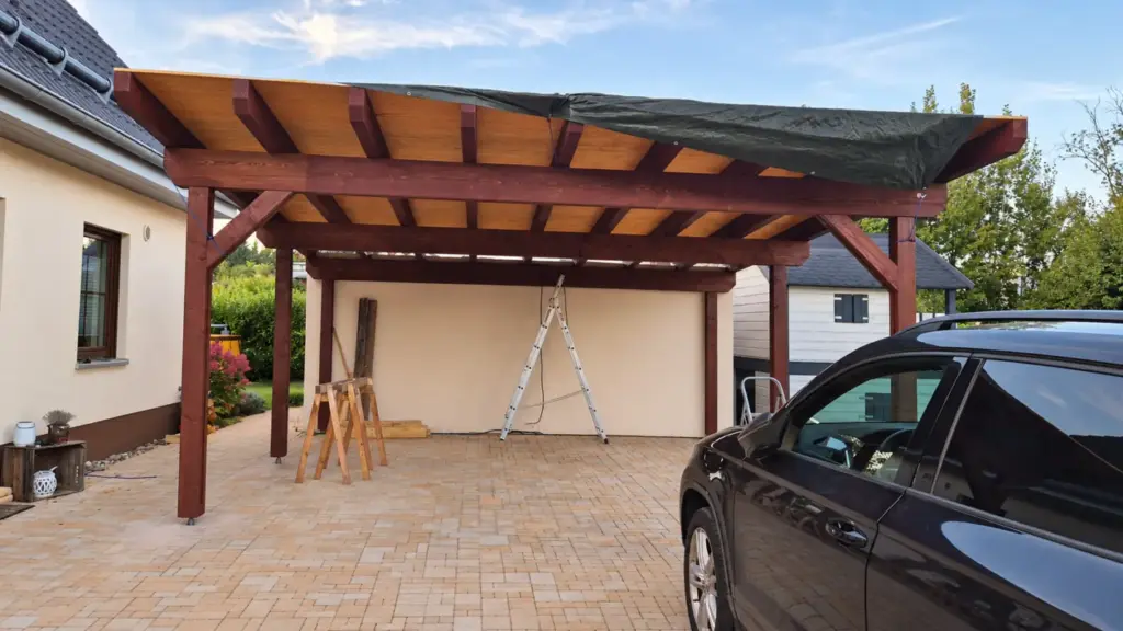 Dachschalung am Carport während der Montage mit bereits verlegtem Rauspund und provisorischer Plane