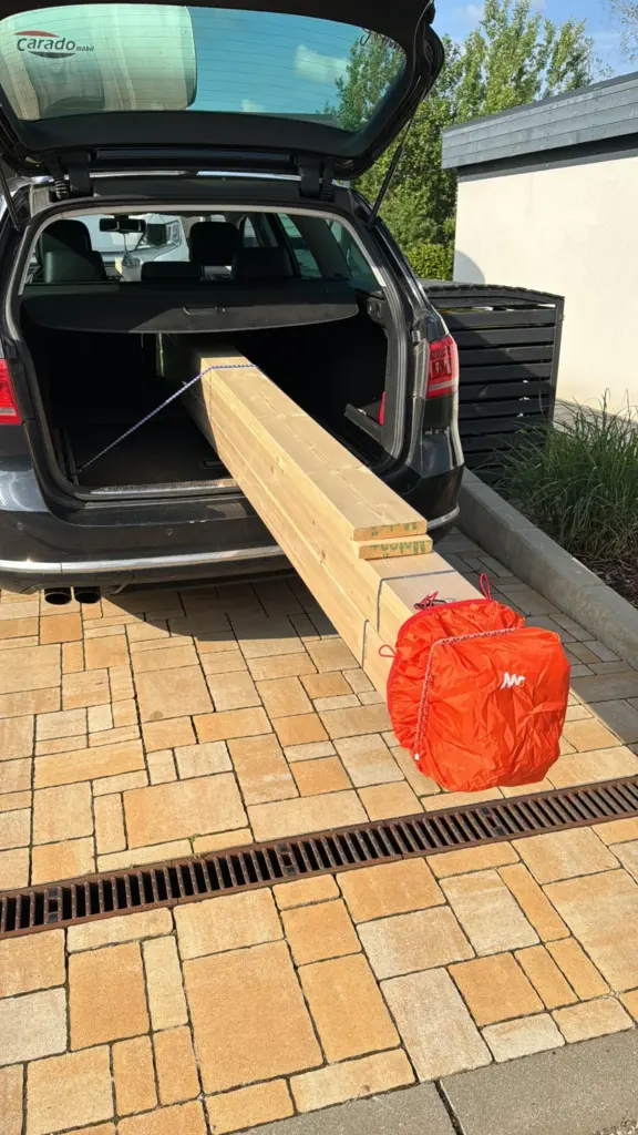 Lange Holzbretter für die Mülltonnenbox beim Materialtransport im Kombi