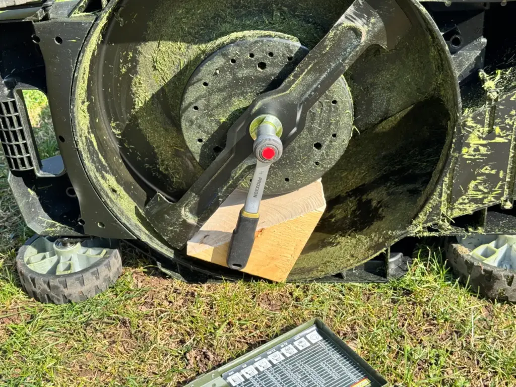 PROXXON 23 110 Ratsche angesetzt am Mähwerk eines Rasenmähers
