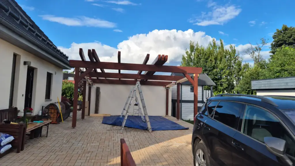 Carport während der Sparrenmontage mit aufliegenden Sparren auf den Pfetten, ohne Personen im Bild