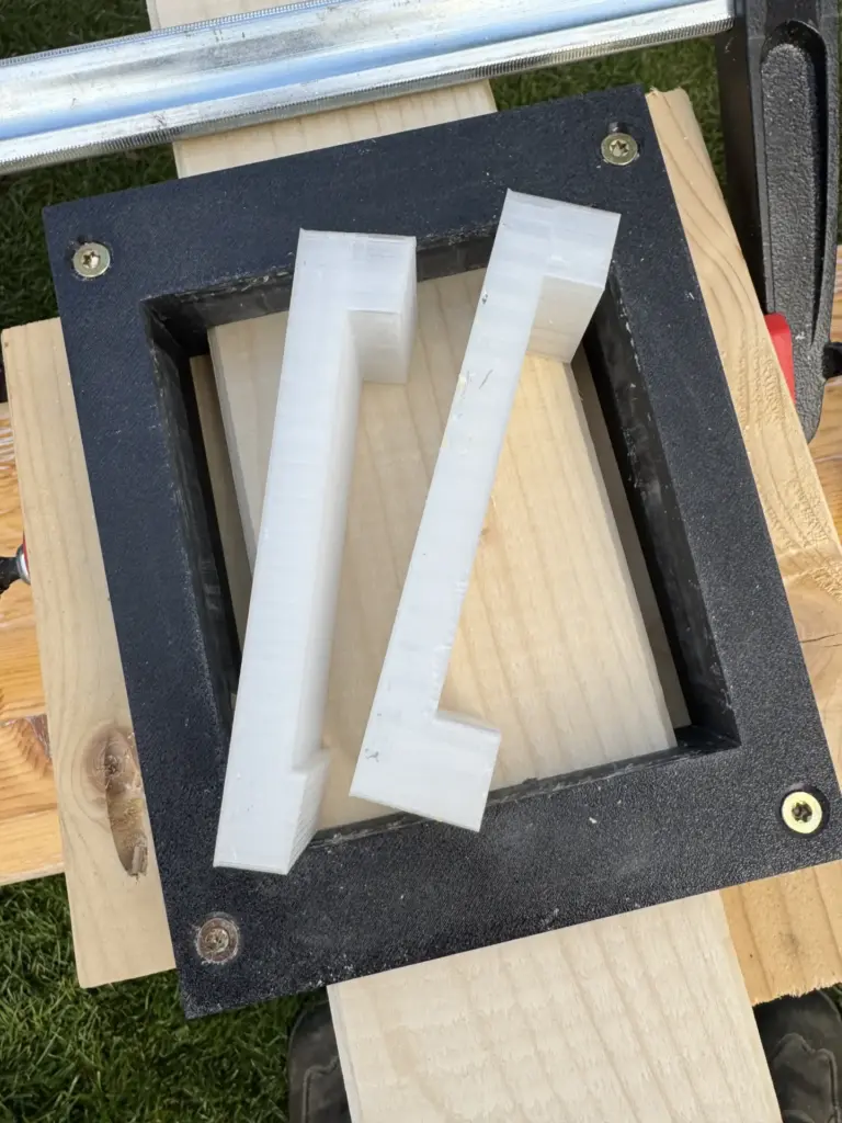 Schwarze Frässchablone mit zwei weißen 3D-gedruckten Einsätzen für die Sparrenauflager am Carport
