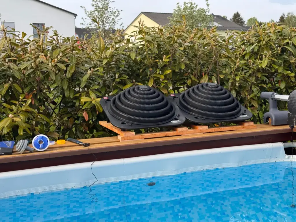 Aufstellpool heizen mit zwei montierten Steinbach Loop Solarkollektoren an der Holzumrandung