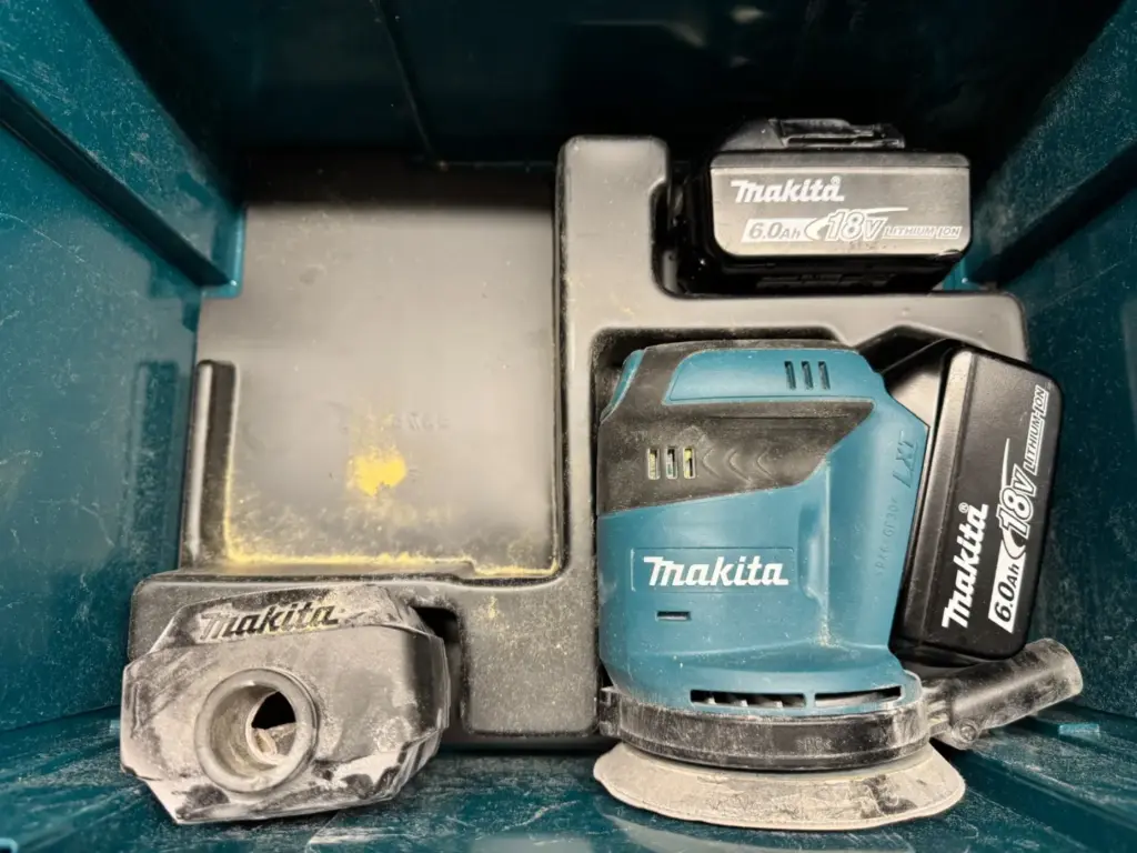 Makita DBO180 mit eingesetztem und separat eingelegtem 18-V-6,0-Ah-Akku