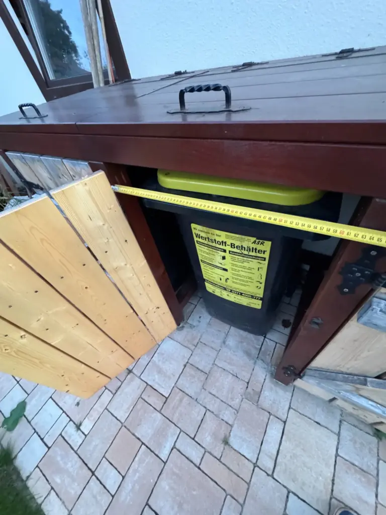 Türöffnung der Mülltonnenbox mit Bosch-Bandmaß und eingesetzter Mülltonne