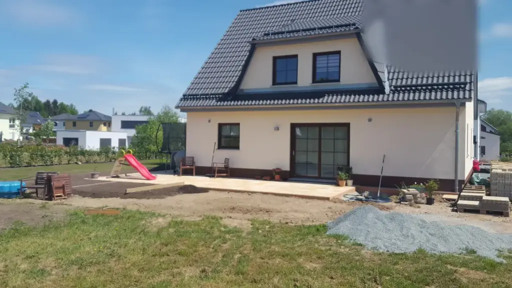 Terrasse pflastern: bereits fertig gepflasterte Terrasse mit später angefüllter Erde am Rand