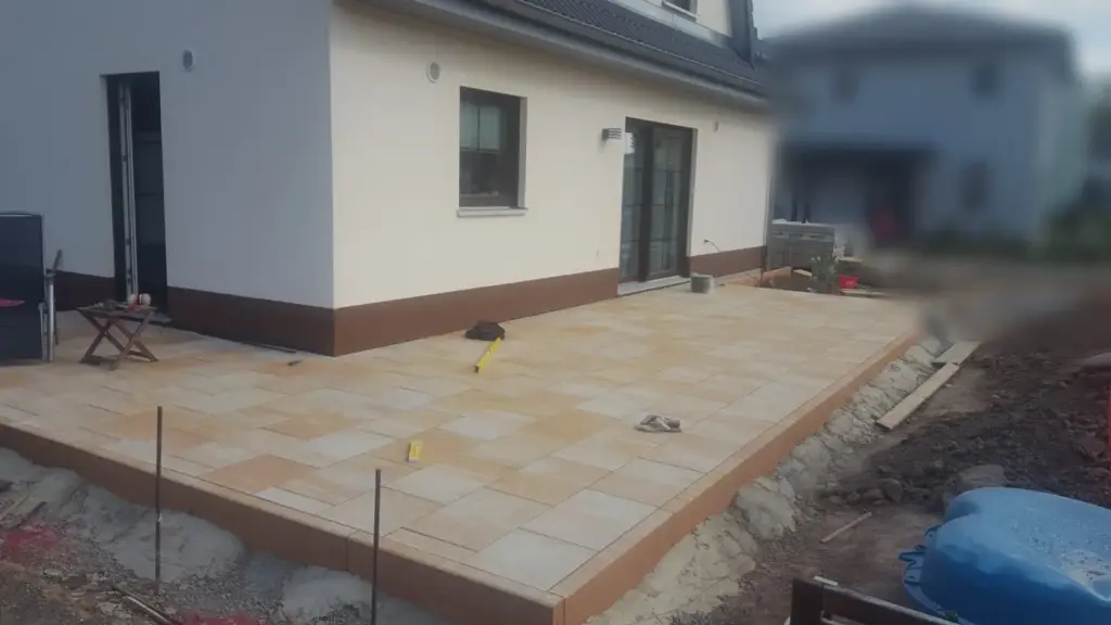 Bereits belegte Terrasse mit offenen Randarbeiten und Arbeitswerkzeug – Terrasse pflastern