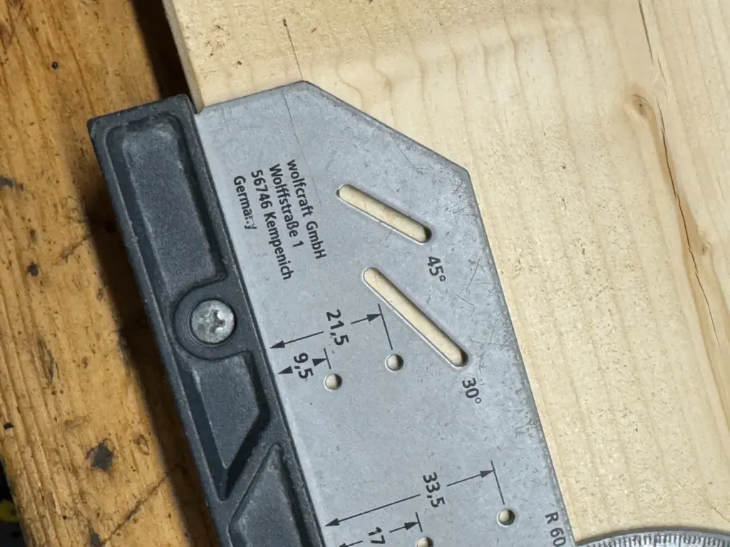 30°- und 45°-beschriftete Anreißschlitze am wolfcraft Universalwinkel 5205000, daneben weitere Markierbohrungen