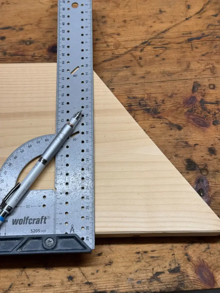 wolfcraft Universalwinkel 5205000 am Rand eines hellen Holzstücks mit Bleistift im Bereich der Winkelskala