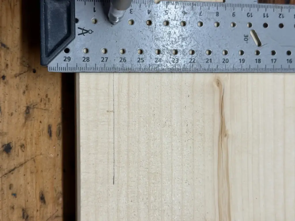wolfcraft Universalwinkel 5205000 am Holzbrett mit sichtbarem Bleistiftanriss entlang des Schenkels