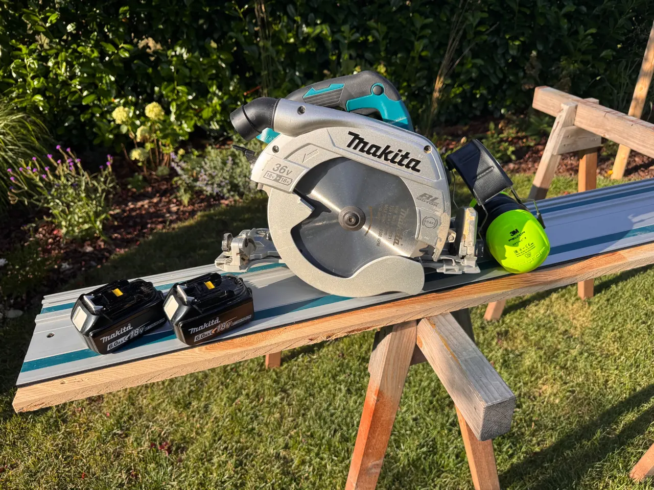 Makita DHS900 auf einer Führungsschiene mit zwei Akkus bei einer eigenen Holzarbeit im Garten